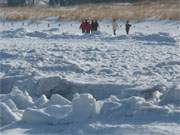 Spaziergang am Winterstrand: Urlaubsgste genieen den Sonnenschein am Ostseestrand.
