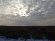 Winterhimmel ber Usedom: Wolken ber dem gefrorenen Achterwasser.